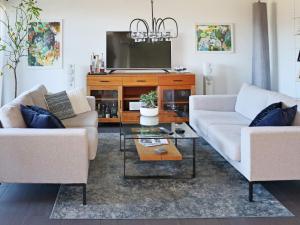 a living room with two couches and a tv at Holiday home Förslöv in Förslöv