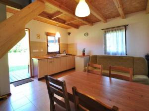 un soggiorno con tavolo in legno e una cucina di Domki letniskowe Pod brzozą a Nowęcin Altre 6 foto