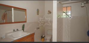 two pictures of a bathroom with a sink and a shower at The View Villa in Port Elizabeth
