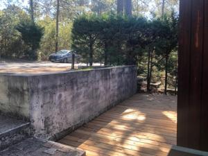 Un muro de contención de hormigón con un coche en un aparcamiento. en CHALET avec PISCINE proche LAC et OCEAN, en Carcans 2 fotos más