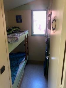 ein kleines Zimmer mit einem Etagenbett und einem Fenster in der Unterkunft CHALET avec PISCINE proche LAC et OCEAN in Carcans