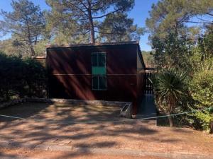 una pequeña casa con techo rojo en CHALET avec PISCINE proche LAC et OCEAN, en Carcans