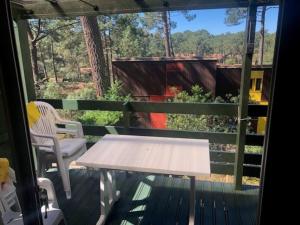 uma mesa branca e uma cadeira num deque em CHALET avec PISCINE proche LAC et OCEAN em Carcans