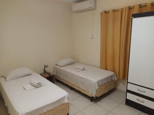 um quarto com duas camas e uma cómoda e um espelho em Beleza Tropical Pousada Hotel em Fortaleza