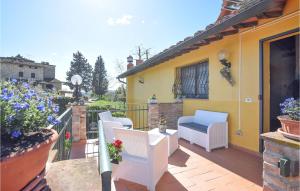 un patio con sedie bianche e una casa gialla di 2 Bedroom Stunning Apartment In Barberino, Tavernelle a Zambra