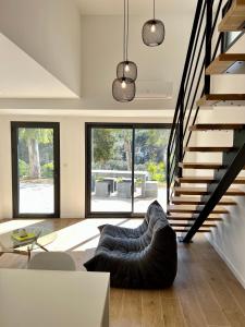 ein Wohnzimmer mit einem Sofa und einer Treppe in der Unterkunft Superbe studio avec accès mer. in Le Pradet