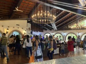 uma multidão de pessoas num grande edifício com um lustre em HOTEL TESORO BEACH em San Luis La Herradura