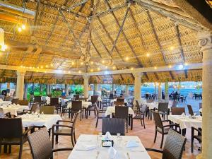 um restaurante com mesas e cadeiras e um tecto grande em HOTEL TESORO BEACH em San Luis La Herradura