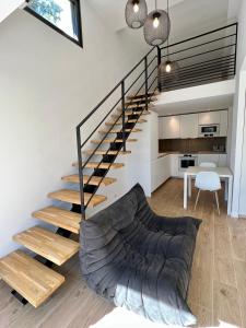 ein Wohnzimmer mit einer Treppe und einer Couch in der Unterkunft Superbe studio avec accès mer. in Le Pradet