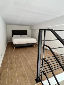 Schlafzimmer mit einem Bett und Holzboden in der Unterkunft Superbe studio avec accès mer. in Le Pradet