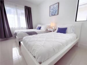 Un dormitorio blanco con dos camas y una ventana. en Casa Relax Total, en Florida City