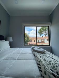 ein Schlafzimmer mit einem großen Bett und einem großen Fenster in der Unterkunft Cal Bed & Breakfast in Bogotá