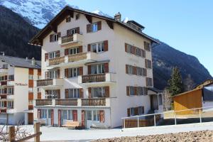 a hotel in the mountains with mountains in the background at Haus Alpenblick in Saas-Grund