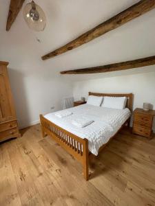 a bedroom with a bed and a wooden floor at The Old Shippon, Barbon in Barbon