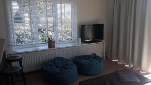 a living room with two stools in front of a window at Residentie Lenthe in De Haan