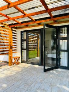 eine offene Terrasse mit Glastüren und einer Holzdecke in der Unterkunft Modern studio apartments in Secunda