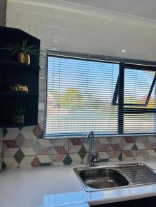 a kitchen counter with a sink and a window at Modern studio apartments in Secunda