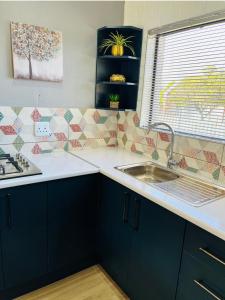 a kitchen with blue cabinets and a sink at Modern studio apartments in Secunda