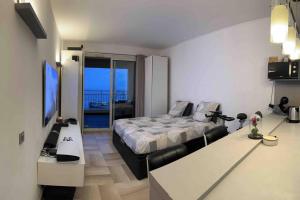 - une chambre avec un lit et un bureau avec une télévision dans l'établissement Studio à Monaco Fontvieille, à Monte-Carlo