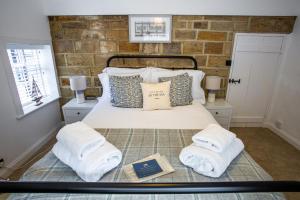 a bedroom with a bed with towels on it at Whitby Boutique - Mast Cottage in Whitby