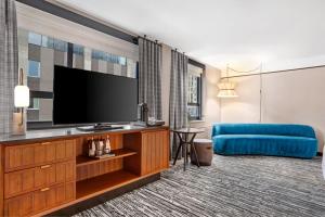 Habitación de hotel con TV de pantalla plana y sofá azul. en Hotel Indigo - Minneapolis Downtown, an IHG Hotel, en Minneapolis