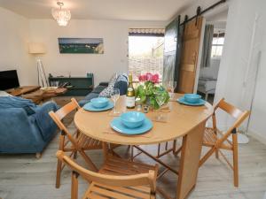 a dining room and living room with a wooden table and chairs at The Stables in Newport