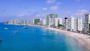 une vue d'une plage avec des bâtiments et l'océan dans l'établissement Ecuabook Aquamira 6D malecón Salinas, à Salinas
