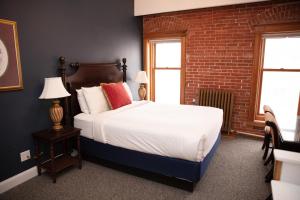 a bedroom with a bed and a brick wall at The Victor Hotel in Victor