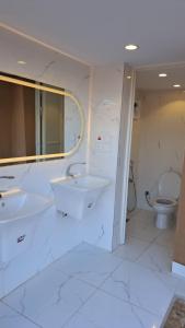 La salle de bains est pourvue de 2 lavabos et de toilettes. dans l'établissement أستراحة مون لايت الريفي, à Al-Ula