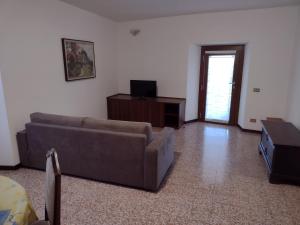 uma sala de estar com um sofá e uma televisão em Appartamento Teoperga em Sotto il Monte
