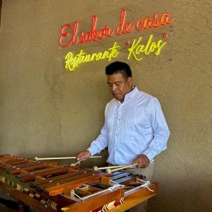 un hombre parado frente a una mesa con un buffet en Hotel Makarios en Tuxtla Gutiérrez