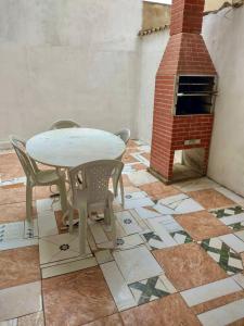 een patio met een tafel en stoelen en een bakstenen oven bij Casa com vista para o por do sol in São Thomé das Letras