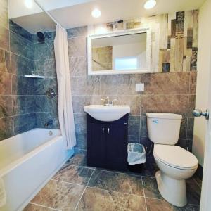 a bathroom with a toilet and a sink and a tub at Motel Bonsoir in Joliette +52 photos