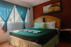 a bedroom with a bed with two towels on it at Hotel Makarios in Tuxtla Gutiérrez