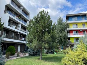 an apartment building with a tree in the yard at Bucharest Airport Henri Coanda & Therme-SELF CHECK-IN in Otopeni
