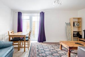 a living room with a table and purple curtains at Ground Floor Apartment City Centre University Free Parking in Sheffield