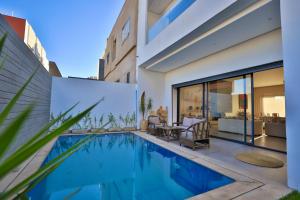 a house with a swimming pool and a patio at Moon house in Ville Nouvelle