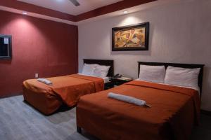 a hotel room with two beds and a painting on the wall at Hotel Makarios in Tuxtla Gutiérrez