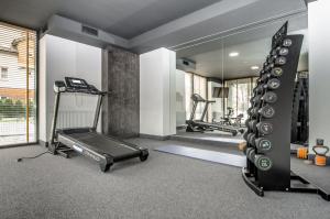 einen Fitnessraum mit einem Laufband und einem Spiegel in der Unterkunft Apartament o2 ALLDAYHOLIDAY Mielno in Mielno