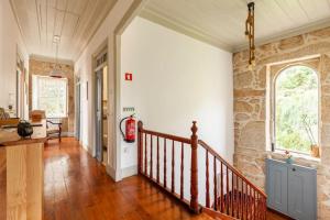 um corredor de uma casa com uma escada e uma parede de pedra em Casa do Cabeço em Caramulo