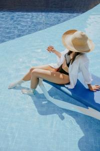 duas mulheres sentadas numa jangada numa piscina em Ixchel Beach Hotel em Isla Mujeres
