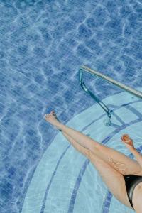 kobieta w basenie z nogami w wodzie w obiekcie Ixchel Beach Hotel w mieście Isla Mujeres