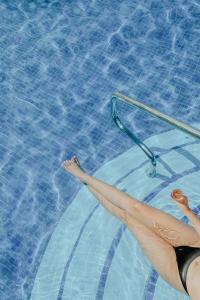 a woman in a swimming pool with her legs in the water at Ixchel Beach Hotel in Isla Mujeres