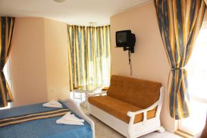 a hospital room with a couch and a tv at Family Hotel Paros 2 in Pomorie