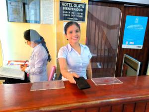 een vrouw staat aan een toonbank in een winkel bij Hotel Olaya in Lima