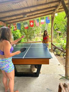 a girl playing ping pong on a ping pong table at Hotel Viejamar con Cocina compartida in Puerto López