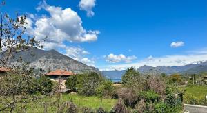 a house in a field with a mountain in the background at La Casa di Ada in Iseo
