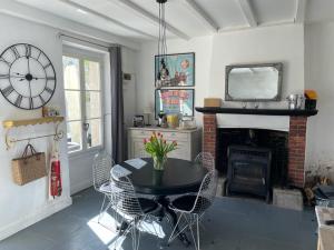 a dining room with a table and a fireplace at Maison Hirondelles Gîtes in Mézières-sur-Issoire