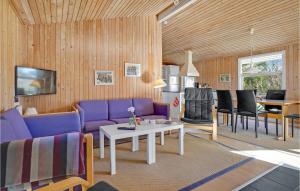 een woonkamer met paarse meubels en een tafel bij Gorgeous Home In Brenderup Fyn With Kitchen in Vedelshave