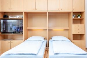 two beds in a room with wooden cabinets at Haus Hanseatic, Wohnung 204 in Duhnen